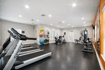 A gym with treadmills, exercise balls, and other equipment.